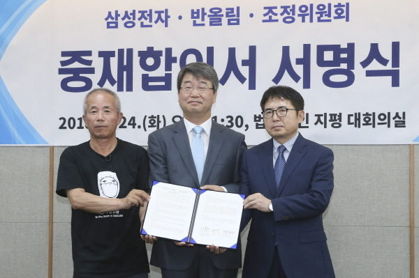 지난 7월 24일 오전 서울 서대문구 법무법인 지평에서 열린 '삼성전자-반올림-조정위 중재 합의서 서명식'에서 고 황유미 씨 아버지 반올림 황상기(왼쪽부터) 대표, 김지형 조정위원장, 김선식 삼성전자 전무가 중재합의서를 들고 기념촬영을 하고 있다.
