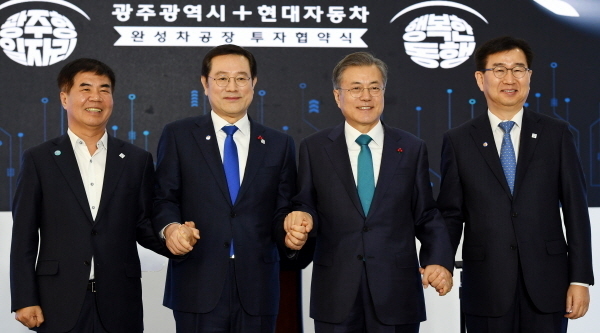 광주전남사진공동기자단 = 문재인 대통령이 31일 오후 광주 서구 광주시청에서 열린 광주형 일자리 투자 협약식에 참석해 이용섭 광주시장과 이원희 현대자동차 대표이사, 윤종해 한국노총 광주지역본부의장과 손을 맞잡고 있다.