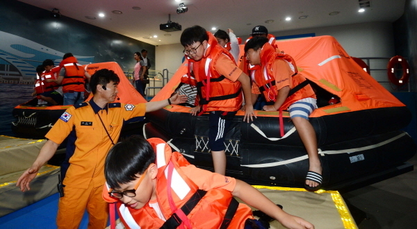 부산119안전체험관에서 선박 사고 발생 시 사용하는 구명뗏목을 체험하고 있는 모습.