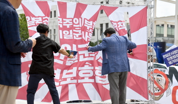 광주전남시민사회단체가 21일 오전 광주 동구 5·18민주광장에서 '경제침략 아베규탄, 한일군사보호협정 폐기 촉구' 기자회견을 한 뒤 일본 군국주의 상징인 욱일기 찢기 퍼포먼스를 하고 있다.