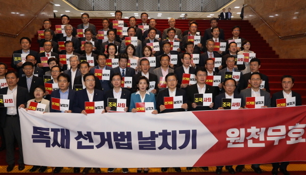 국회 정치개혁특별위원회가 준연동형비례대표제 도입을 골자로 하는 공직선거법 개정안을 의결한 29일 서울 여의도 국회에서 자유한국당 의원들이 이를 규탄하며 피켓을 들고 구호를 외치고 있다.