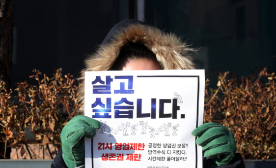 '사회적거리두기 단계 개편을 위한 공개토론회'가 열린 2일 오전 서울 중구 LW컨벤션에 마련된 토론회장 앞에서 자영업자들이 방역지침 끝장토론, 영업시간 연장 등을 촉구하는 1인 시위하고 있다.