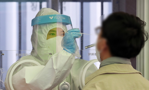 지난 23일 오후 서울 중구 서울역광장에 마련된 코로나19 중구임시선별검사소에서 의료진이 검체 채취를 하고 있다.