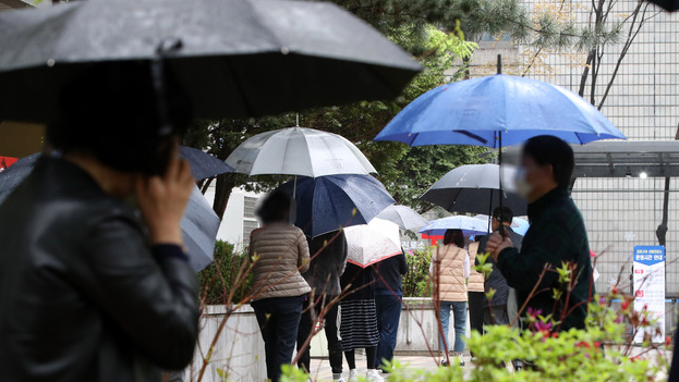 지난 12일 오후 서울 서초구 서초보건소에 마련된 코로나19 선별진료소에서 시민들이 검사를 받기 위해 줄 서 있다.