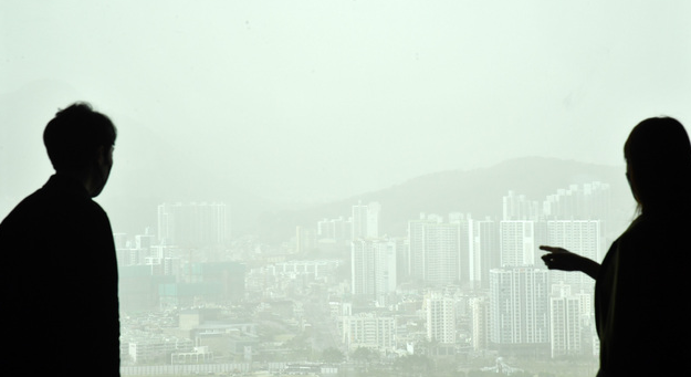 2010년 11월 11일 이후 처음으로 부산지역에 황사경보가 발령된 지난 3월29일 오후 부산 부산진구 롯데호텔에서 직원들이 뿌옇게 변한 도심을 바라보고 있다. 황사경보는 1시간 평균 미세먼지(PM-10) 농도가 800㎍/㎥ 이상인 상태가 2시간이상 지속될<br>
것으로 예상될 때 발령된다. 