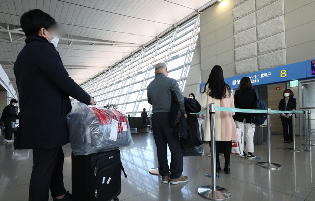 무착륙 관광비행을 떠나는 승객들이 지난해 12월 오전 인천국제공항 1터미널 면세점에서 구입한 물품을 들고 항공기에 탑승하고 있다.