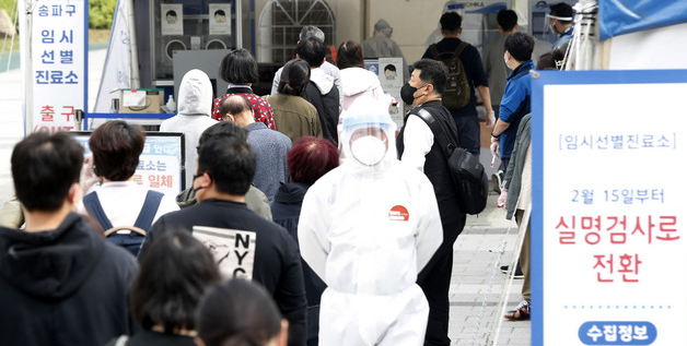 코로나19 신규 확진자가 775명으로 집계된 28일 서울 송파구 올림픽공원 앞에 마련된 임시선별진료소에서 시민들이 검사를 받기 위해 길게 줄지어 기다리고 있다.
