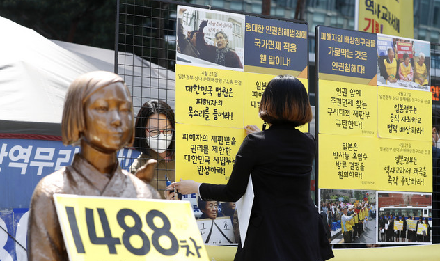 일본군 '위안부' 피해자들이 일본 정부를 상대로 낸 2차 손해배상 청구 소송에서 각하 판결이 나온 지난달 21일 서울 종로구 일본대사관 앞에서 열린 제1488차 일본군성노예제 문제해결을 위한 정기 수요시위 기자회견을 앞두고 정의기억연대(정의연) 관계자들이 사법부를 규탄하는 문구를 부착하고 있다.