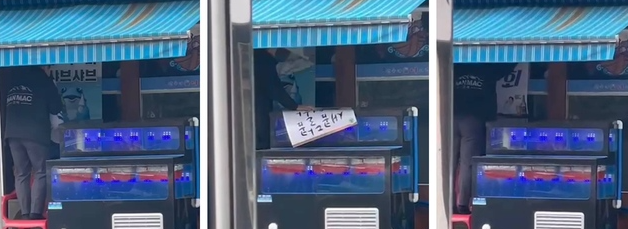 지난달 30일 인천 관교동에서 오비맥주 직원이 하이트진로의 홍보물을 뜯어내는 모습.(사진=하이트진로 제공)