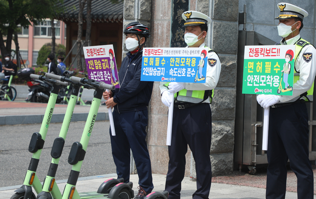 전주시 자전거정책과 관계자들과 전주 덕진경찰서, 완산경찰서 경찰관들이 21일 전북 전주시 전북대학교 구정문 앞에서 개인형 이동 장치(PM) 안전이용문화 정착을 위한 합동 캠페인을 하고 있다.