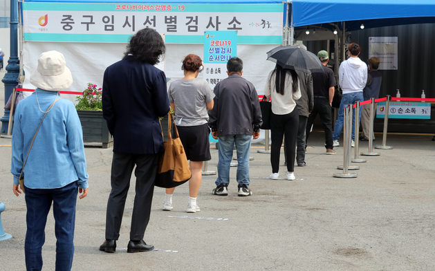 코로나19 신규 확진자수가 다시 500명 대로 내려간 지난 23일 오전 서울 중구 서울역광장에 마련된 중구임시선별검사소에서 시민들이 줄을 서고 있다.