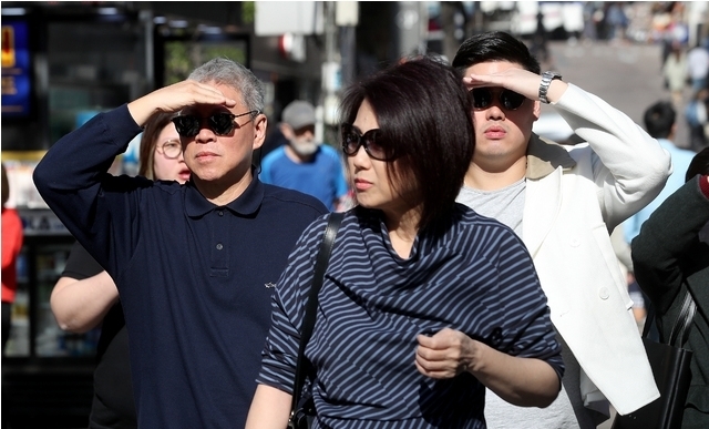 낮 최고기온 23도를 기록하며 초여름 날씨를 보이는 17일 오후 서울 중구 명동에서 썬글라스를 착용한 외국인 관광객들이 손으로 햇빛을 가리고 있다. (2019년 4월)