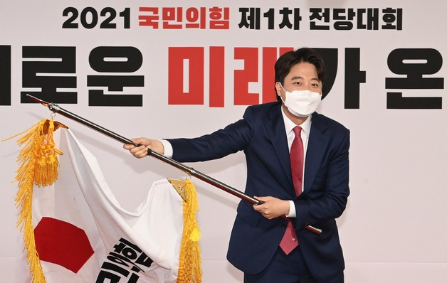 이준석 국민의힘 대표 당선자가 11일 오전 서울 영등포구 여의도동 국민의힘 당사에서 열린 전당대회에서 당기를 흔들고 있다. (공동취재사진)