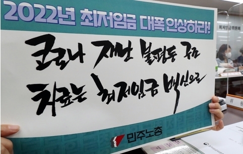 지난 15일 오후 정부세종청사 고용노동부에서 열린 2022년 적용 최저임금 심의를 위한 최저임금위원회 3차 전원회의에 근로자측 위원들이 손 피켓을 들고 있다. 이번 3차 전원회의에는 근로자위원, 사용자위원, 공익위원들이 전원 참석했다. (공동취재사진)