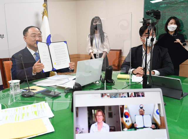 홍남기 경제 부총리 겸 기획재정부 장관이 지난 22일 오후 정부서울청사에서 오딜 르노-바소 유럽부흥개발은행(EBRD) 총재와 화상으로 면담 후 한국의 EDCF 신탁기금 추가 출연, 초기체제전환기금 추가 출연과 중소기업지원기금 납입 협정문을 보이고 있다. (사진=기획재정부 제공) 