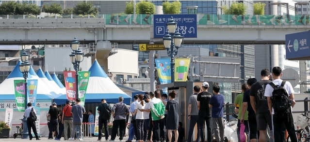 지난 27일 오전 서울 중구 서울역 임시선별검사소를 찾은 시민들이 검사를 받기 위해 줄을 서고 있다.