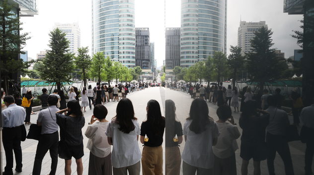 코로나19 신규확진자가 1212명 발생한 7일 오전 서울 강남구 삼성역6번출구 임시선별검사소에서 검사를 받기 위해 인근까지 길게 줄서 기다리고 있는 모습이 건물에 반영되고 있다. 