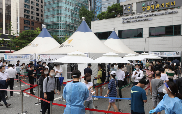 코로나19 신규확진자가 1212명 발생한 7일 오후 서울 강남구보건소 코로나19 선별진료소에서 검사를 받기 위해 길게 줄서 기다리고 있다.