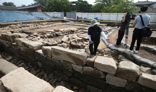문화재청 관계자가 8일 오전 서울 종로구 경복궁 동궁 권역에서 발굴된 150년 전(추정) 선진 정화시설을 갖춘 공중화장실 유구(遺構) 현장에 대해 설명하고 있다.