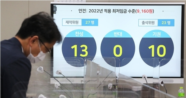 박준식 최저임금위원회 위원장(오른쪽)이 12일 밤 제9차 전원회의에서 내년도 최저임금을 9천160원으로 의결한 뒤 위원들과 대화하고 있다.(공동취재사진) 2021.07.13