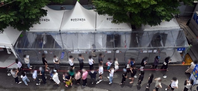 지난 13일 부산 부산진구보건소 선별진료소를 찾은 시민들이 코로나19 진단검사 검체 채취를 위해 길게 줄을 선 채 자신의 차례를 기다리고 있다. 2021.07.13.