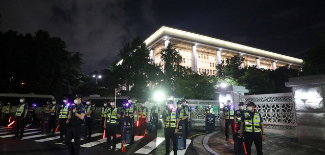  '코로나19 대응 전국자영업자비상대책위원회'의 거리두기 4단계 조치 항의 심야 차량 시위가 예정된 14일 오후 서울 여의도 국회둔치주차장 인근 국회 게이트 앞에서 경찰 병력이 대기하고 있다. 