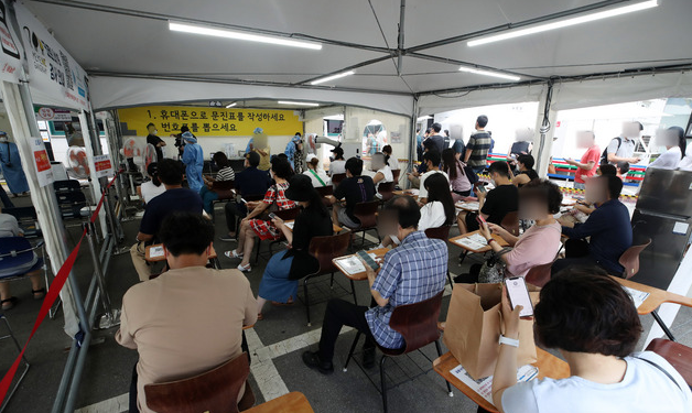 코로나19 신규 확진자가 1,600명으로 집계된 15일 오전 서울 강남구보건소에 설치된 선별진료소에서 시민들이 검사를 받기 위해 대기하고 있다. 