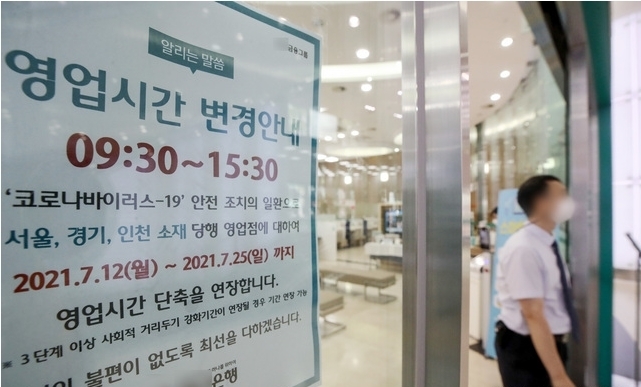 수도권 내 사회적 거리두기 4단계 시행 첫 날인 지난 12일 오후 서울 시내 한 은행에 1시간 단축 운영 안내문이 부착돼 있다. 2021.07.12.