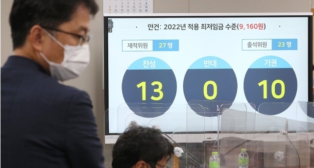 박준식 최저임금위원회 위원장(오른쪽)이 지난 12일 밤 제9차 전원회의에서 내년도 최저임금을 9천160원으로 의결한 뒤 위원들과 대화하고 있다. (공동취재사진) 2021.07.13 