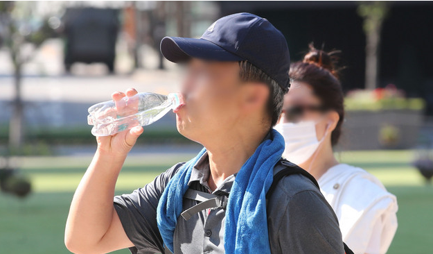 폭염이 이어지고 있는 16일 오전 서울 중구 서울광장 인근에서 한 시민이 물을 마시며 이동하고 있다. 