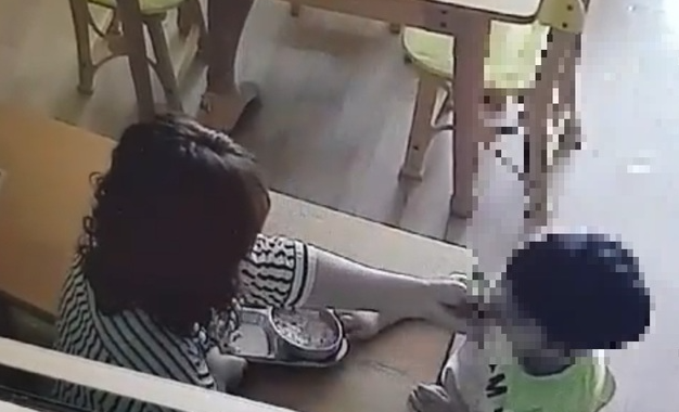 경남 사천에 위치한 어린이집이 제공한 폐쇄회로(CC)TV 영상. 해당 영상에는 한 보육교사가 밥 먹기를 거부하면서 고개를 돌리는 아이의 입 안에 음식을 억지로 밀어넣고, 손등을 수차례 내려치는 등의 모습이 담겨있다. (사진 = CCTV 영상 갈무리)