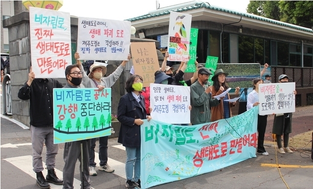 비자림로를 지키기 위해 뭐라도 하려는 시민모임이 제주도청 정문 앞에서 비자림로 확장 공사 중단을 촉구하고 있다.