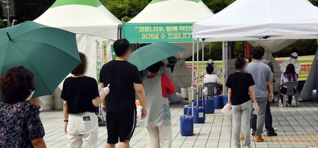 지난 21일 오전 연제구 부산시청 등대광장 임시선별검사소를 찾은 시민들이 진단검사를 받기 위해 줄을 선채 차례를 기다리고 있다. 2021.07.21.