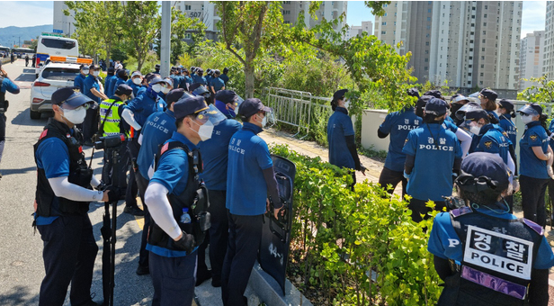  23일 오후 경찰이 강원도 원주시 국민건강보험공단 사옥 인근 인도에서 언덕을 넘어 집결하는 민주노총 노조원들의 진입을 차단하기 위해 경계근무를 서고 있다. (사진=독자 제공)