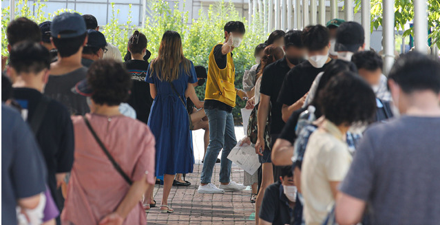 국내 코로나19 신규 확진자가 1,630명을 기록한 23일 오전 서울 마포구 서강대역 광장 임시선별검사소에서 시민들이 검사를 받기 위해 줄 서 있다. 