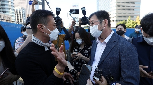 광화문 광장 재구조화 공사를 위해 '세월호 기억공간' 철거를 앞둔 26일 서울 종로구 광화문 광장 세월호 기억공간 앞에서 서울시 김혁(오른쪽) 총무과장이 4.16연대 김선우 사무처장에게 자진 철거를 요구하고 있다. 2021.07.26.