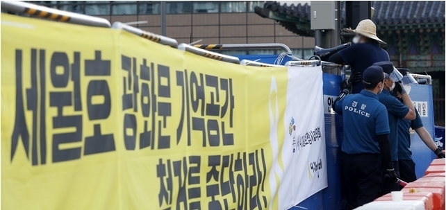 광화문 광장 재구조화 공사를 위해 '세월호 기억공간' 철거를 앞둔 26일 서울 종로구 광화문 광장 세월호 기억공간 앞에서 보수단체 한 회원이 펜스 가까이 다가가 규탄발언을 하자 경찰이 제지하고 있다. 2021.07.26.