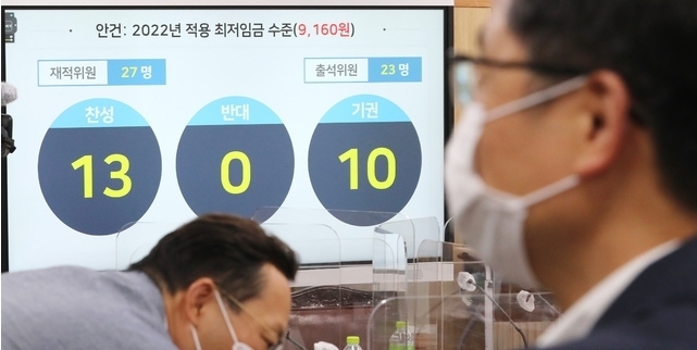 박준식 최저임금위원회 위원장(오른쪽)이 지난달 12일 밤 제9차 전원회의에서 내년도 최저임금을 9천160원으로 의결한 뒤 위원들과 대화하고 있다.(공동취재사진) 2021.07.13