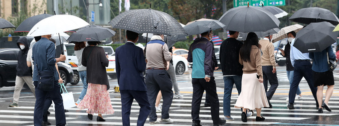 가을비가 내리고 있는 지난 8일 오후 서울 종로구 광화문네거리에서 시민들이 우산을 쓰고 걸어가고 있다.
