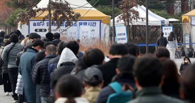  코로나19 신규 확진자수가 이틀 연속 7000명 대를 보인 9일 오후 서울 송파구 문정도시개발구역 광장 임시선별검사소에서 시민들이 코로나19 검사를 받기 위해 줄지어 서 있다.