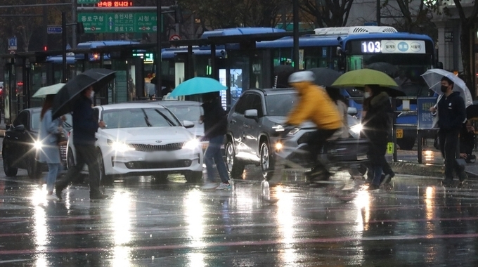  전국에 겨울비가 내린 지난달 30일 오전 세종대로 사거리에서 우산을 든 시민들이 출근길 발걸음을 옮기고 있다.