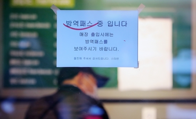  학원 등에 청소년 방역패스(접종증명·음성확인제)를 적용하는 시기가 기존 2월에서 미뤄질 것으로 보인다. 정부는 관련 개선안을 오는 31일 오전 중 발표할 예정이다. 30일 오후 서울 중구의 한 카페에 방역 패스 안내문이 붙어 있다. 
