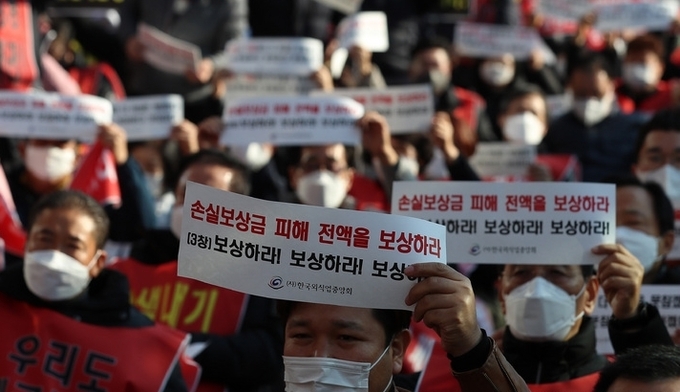  8일 오후 서울 영등포구 국회의사당역 인근에서 열린 코로나19 피해 실질 보상 촉구 정부·여당 규탄대회에서 참석자들이 구호를 외치고 있다.