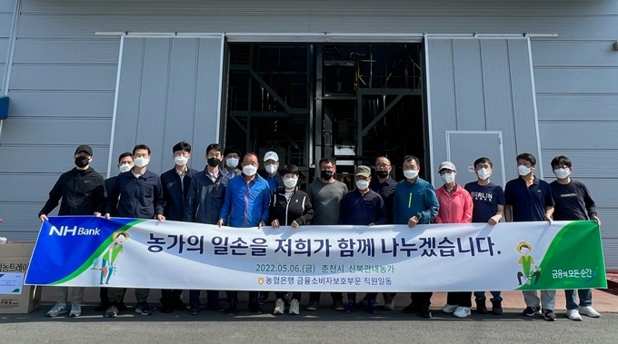 NH농협은행 금융소비자보호부문 이수경 부행장(첫줄 왼쪽에서 6번째)과 직원들은 강원 춘천시 소재 농가를 찾아 일손돕기를 실시하고 기념사진을 촬영하고 있다. ⓒ 파이낸셜데일리 / NH농협은행