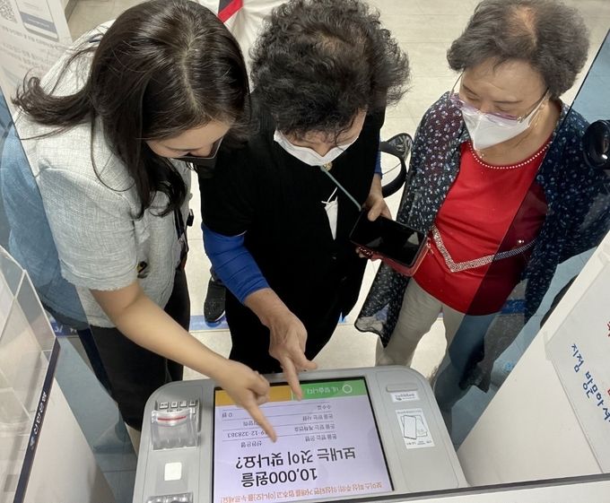 시니어 고객이 보조강사와 함께 신한은행 하계동지점에서 ‘시니어 고객용 맞춤형 서비스’를 적용한 ATM 기기를 체험하고 있는 모습 ⓒ 파이낸셜데일리 / 신한은행