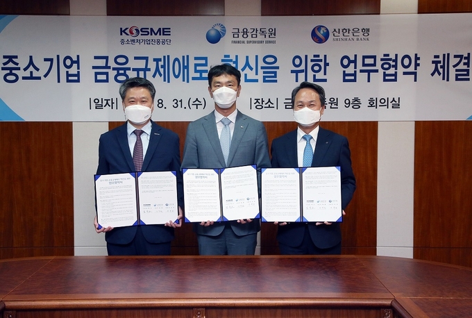 31일 서울시 영등포구 소재 금융감독원 회의실에서 진행된 협약식에서 신한은행 진옥동 은행장(오른쪽), 중소벤처기업진흥공단 김학도 이사장(왼쪽), 금융감독원 이복현 원장(가운데)이 기념촬영 하는 모습 ⓒ 파이낸셜데일리 / 신한은행