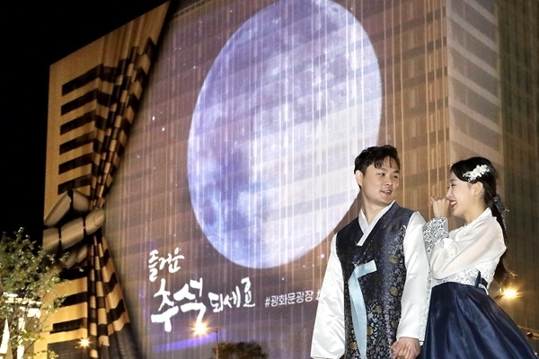 KT 모델들이 광화문광장에서 초대형 보름달을 관람하는 모습. ⓒ 파이낸셜데일리 / KT