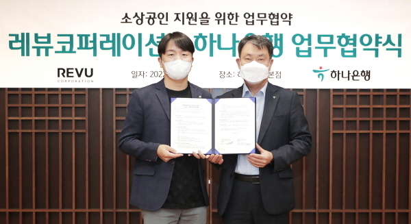 하나은행은 지난 16일 하나은행 을지로 본점에서 ‘인플루언서 마케팅’ 전문 플랫폼 기업 레뷰코퍼레이션과 「소상공인 지원을 위한 업무협약」을 체결했다고 밝혔다. 업무협약식에 참석한 성영수 하나은행 CIB그룹 부행장(사진 오른쪽)이 장대규 레뷰코퍼레이션 대표이사(사진 왼쪽)과 함께 기념촬영을 하고 있다. ⓒ 파이낸셜데일리 / 하나은행
