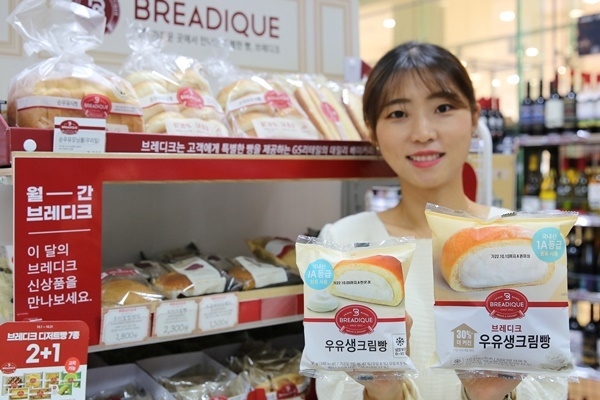 모델이 GS25 브레디크 우유생크림빵 '30% 더 커진 리뉴얼 상품'(오른쪽)을 들고 있다. ⓒ 파이낸셜데일리 / GS리테일