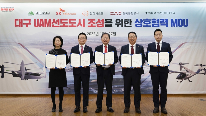 오른쪽부터 박서하 티맵모빌리티 미래모빌리티담당, 유영상 SKT CEO, 홍준표 대구시장, 어성철 한화시스템 대표이사, 이미애 한국공항공사 부사장이 업무협약을 체결하는 모습 ⓒ 파이낸셜데일리 / SK텔레콤